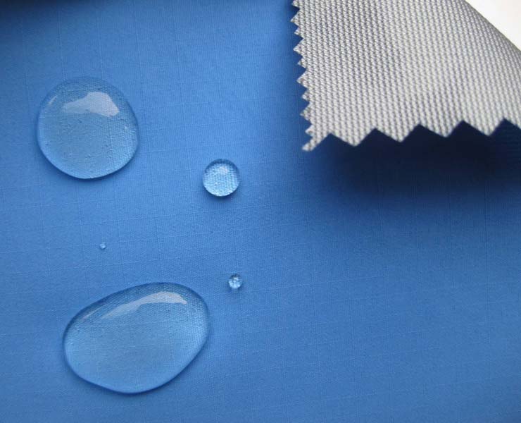 A blue fabric with water droplets on it.