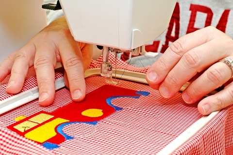 woman sitting at an embroidery machine TeachYouToSew